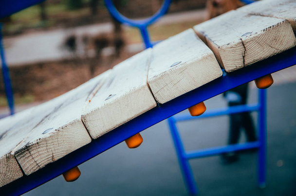 Un pont fait de seuils de bois sur un support en métal bleu. Le pont pour les enfants. Pont de lamelles en bois clair en macro
 - Photo, image