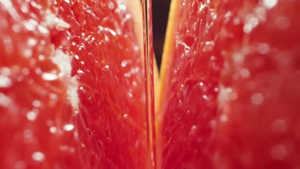4k macro video of pouring water and falling droplets on cut in half fresh tasty grapefruit. Perfect abstract shot for organic food and healthy nutrition. - Footage, Video