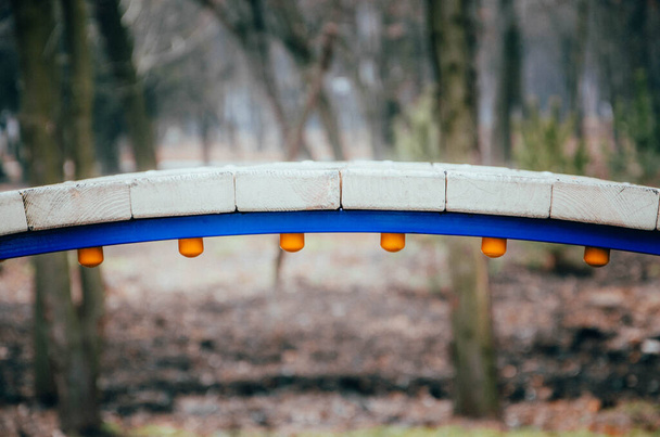 Sillan, joka on tehty puulaudoista sinisellä metallituella. Silta lapsille. Silta kevyt puinen säleet makro
 - Valokuva, kuva