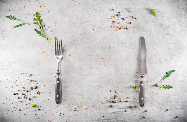 Blank gray stoned table with dishes fork and knife. Food invitation. Ready to serve and cook fresh meal. Copy empty space. Top view - flat lay - Foto, immagini