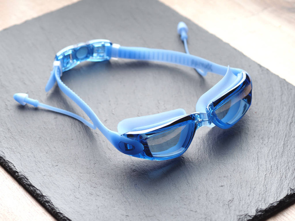 Profesionální modré brýle pro plavání na šedém pozadí - Fotografie, Obrázek