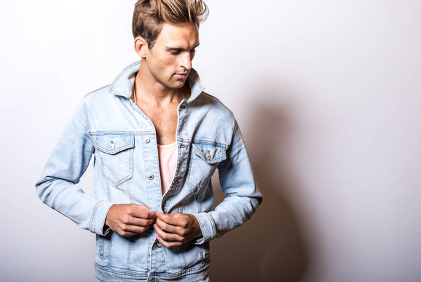 Handsome young man in jeans jacket pose in studio. - Фото, зображення