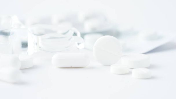 Белые медицинские таблетки, крупный план на белом фоне. Фотография крупным планом медицинских препаратов с копировальными спаами.Макро фото
. - Фото, изображение