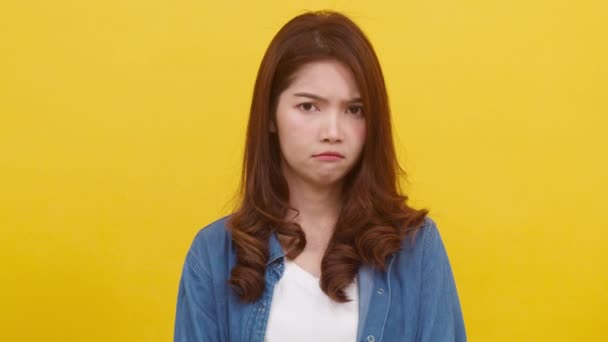 Adorable young Asian female with positive expression, smile broadly, dressed in casual clothing and looking at camera over yellow background. Happy adorable glad woman rejoices success. Slow motion. - Footage, Video