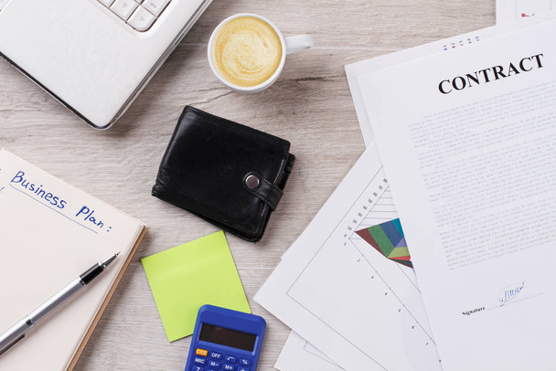 Stationery, laptop, coffee and contract. - 写真・画像