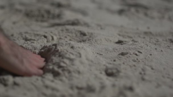 Κοντινό πλάνο σε ένα αντρικό χέρι που αγγίζει την αμμουδιά. Αργή κίνηση πραγματική ζωή - Πλάνα, βίντεο