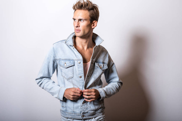 Handsome young man in jeans jacket pose in studio. - Foto, immagini
