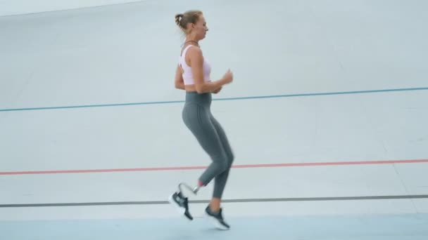 Mulher com deficiência fazendo altas torneiras de joelho durante o treino. Jogging atleta em pista de corrida
 - Filmagem, Vídeo