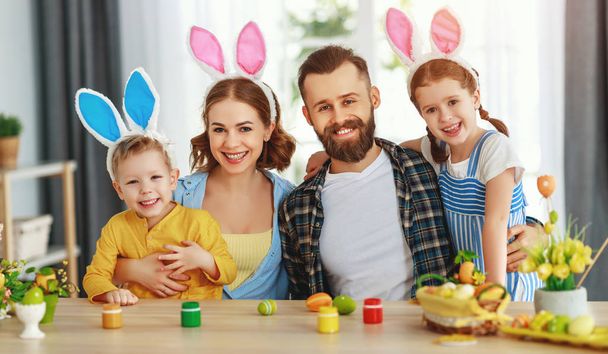 ¡Feliz Pascua! familia madre, padre e hijos pintan huevos para la holida
 - Foto, imagen
