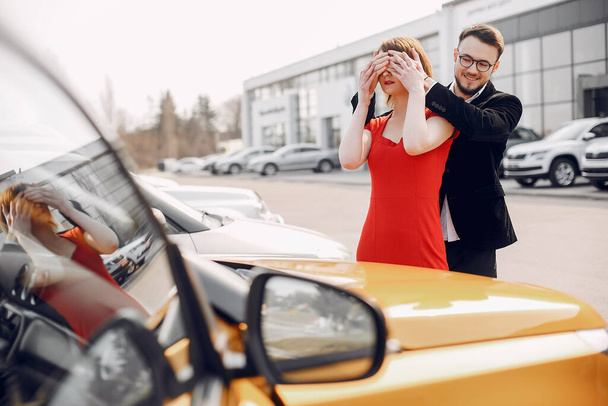 Stylish and elegant couple in a car salon - Valokuva, kuva