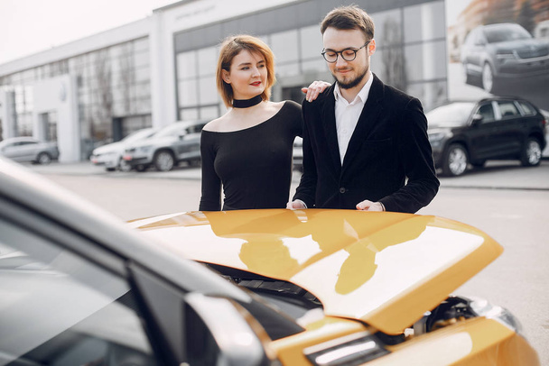 Stylish and elegant couple in a car salon - Fotoğraf, Görsel