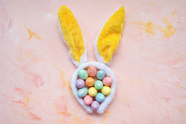 Easter eggs and rabbit ears on pink background - Foto, Bild