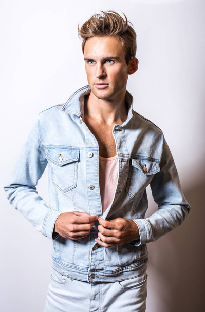 Handsome young man in jeans jacket pose in studio. - Фото, изображение