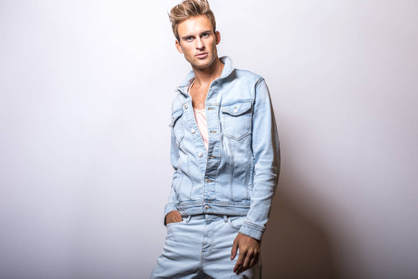 Handsome young man in jeans jacket pose in studio. - Foto, imagen