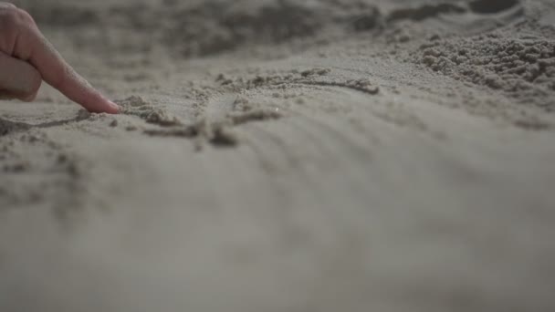 Nahaufnahme eines Mannes, der mit der Hand den Sandstrand berührt. Zeitlupe im echten Leben - Filmmaterial, Video