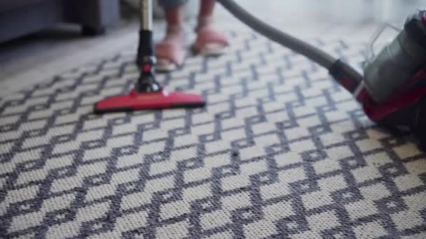 Młoda kobieta używająca odkurzacza do czyszczenia dywanu - Materiał filmowy, wideo