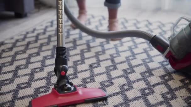 Młoda kobieta używająca odkurzacza do czyszczenia dywanu - Materiał filmowy, wideo