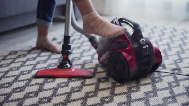 Mujer encendió la aspiradora y empezar a limpiar la alfombra
 - Imágenes, Vídeo