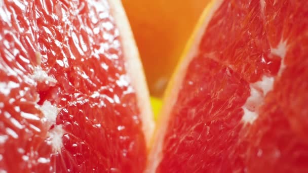 Closeup video of camera moving between two halves of freshly cut orange or grapefruit. Perfect abstract shot for organic food and healthy nutrition. Closeup of citrus fruits - Footage, Video