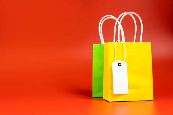 Bolsas de regalo o compras amarillas y verdes aisladas en rojo
 - Foto, imagen