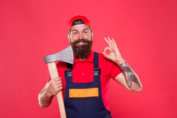 forester hold the ax. man in uniform cut beard hair with ax. brutal bearded man use axe. Hike vacation. Brave enough. better use blade in barbershop. Brutal and bearded. man show ok gesture - Fotó, kép