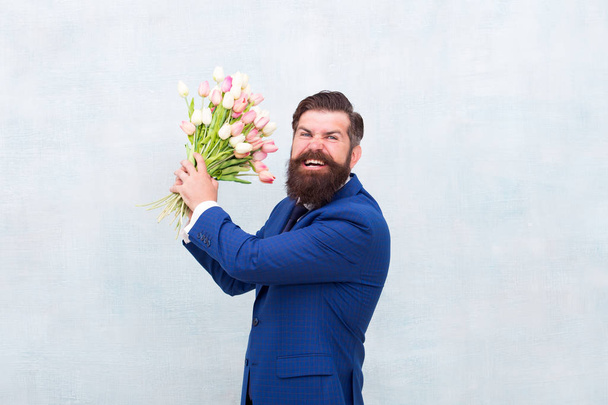 Angry bearded man with flowers. Celebrate spring. Date failure. Irritated annoyed aggressive bearded man with tulip bouquet. Disappointed concept. Failed date. Hate holidays. Womens day. March 8 - Valokuva, kuva