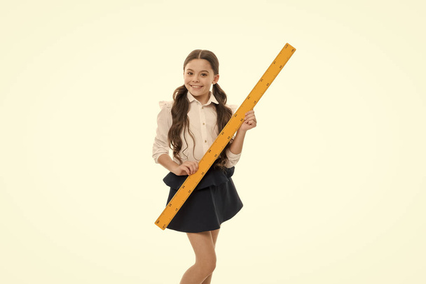 Education and school concept. School student learning geometry. Kid school uniform isolated white. STEM concept. Draw geometric figures. Pupil cute girl with big ruler. Favorite school subject - Photo, Image