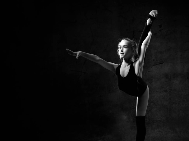 Flexible skinny girl posing in vertical split - Фото, зображення