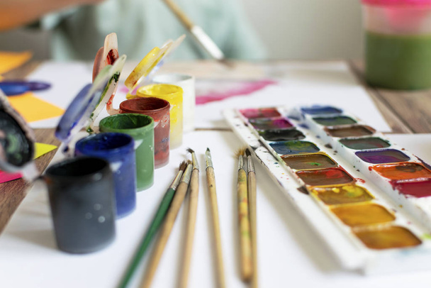 A gyerek fest. Akvarell, gouache, ecsetek, színes és viaszos zsírkréták, matricák. Rajzolás, kreativitás és hobbi. - Fotó, kép