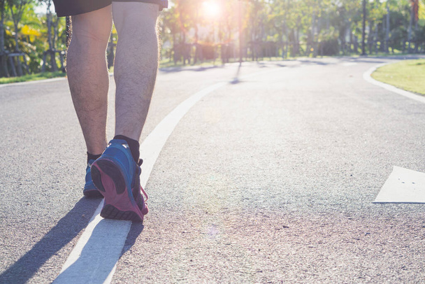 Nahaufnahme Schuh. Männliche Beine beim Joggen und Gehen im Park. Sport- und Bewegungskonzept - Foto, Bild