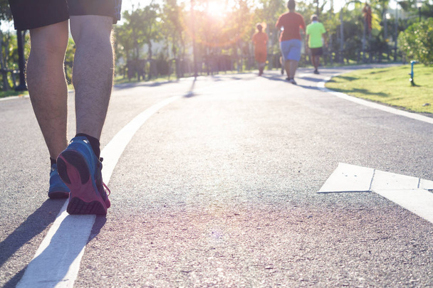 Взуття крупним планом. Чоловічі ноги бігають і ходять в парку. Концепція спорту та фізичних вправ
 - Фото, зображення