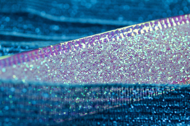 Macro view of beautiful defocused sparkling blue and white fabric ribbon texture background with bokeh - Foto, Imagen