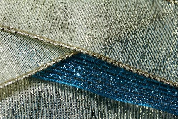 Fondo abstracto macro de brillantes texturas de cinta de tela azul y oro con bokeh
 - Foto, imagen