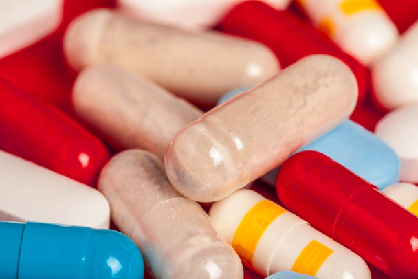 Many medicine pills close up on red background - Фото, изображение