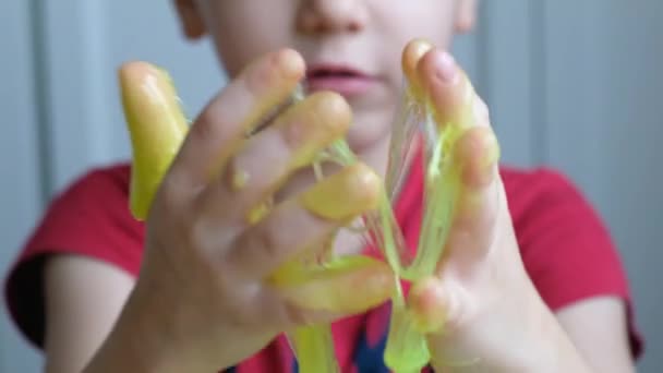 Little child boy toddler playing with light green slime. Close up - Imágenes, Vídeo