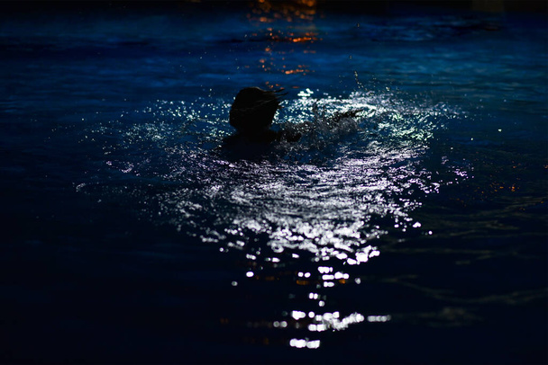 El chico se ahoga por la noche en la piscina del hotel
. - Foto, imagen