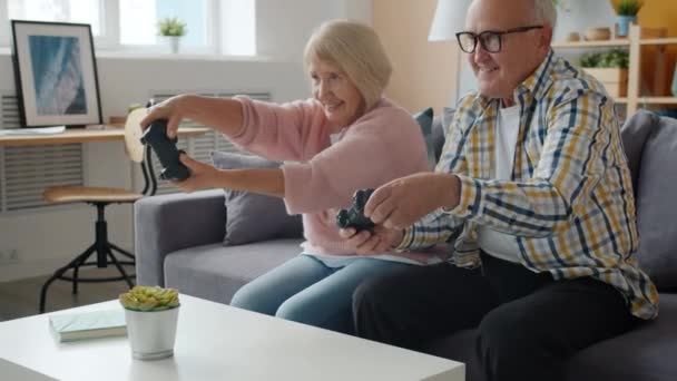 Slow motion of happy old people playing video game at home enjoying leisure fun - Footage, Video