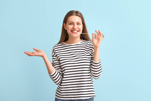 Funny young woman with chewing gum on color background - Photo, Image