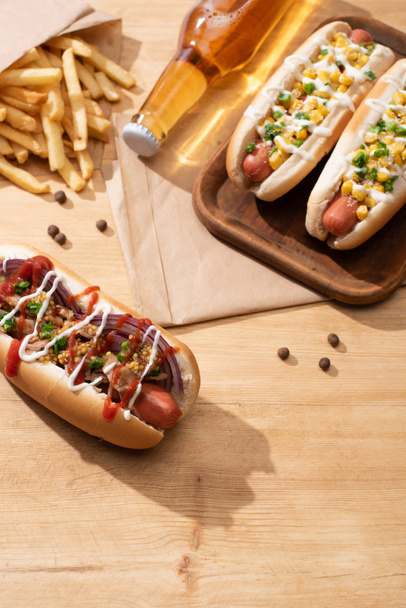 delicious hot dogs near beer and french fries on wooden table - Photo, Image