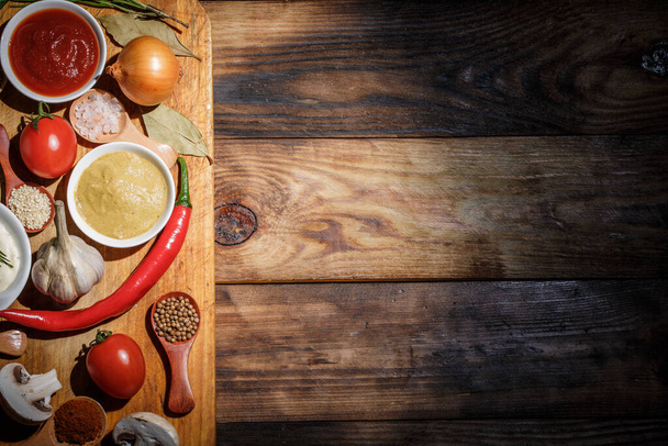 A lot of different spices, vegetables and ingredients for cooking on a wooden background - Φωτογραφία, εικόνα