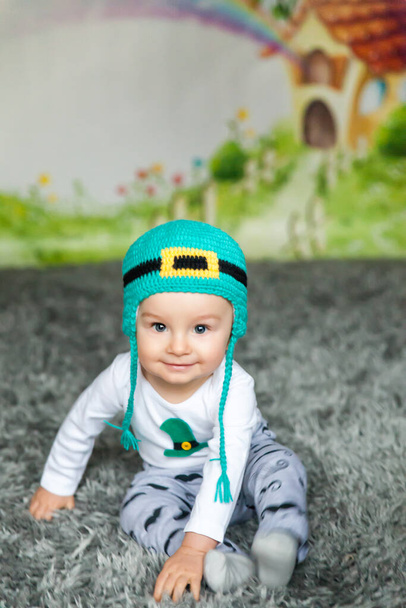Erster Geburtstag süßes Baby mit einem St. Patrick 's Day Hut. Cartoon-Märchenhaus auf Hintergrund - Foto, Bild