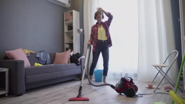 Jonge vrouw met behulp van een stofzuiger op de vloer - Video