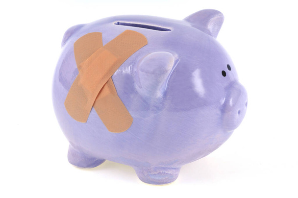 Piggy bank met bandage close-up op witte achtergrond  - Foto, afbeelding