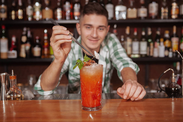 Detailní záběr lahodného koktejlu s ledem, profesionální barman zdobí. Barman pracuje ve své restauraci, připravuje pití pro zákazníka - Fotografie, Obrázek