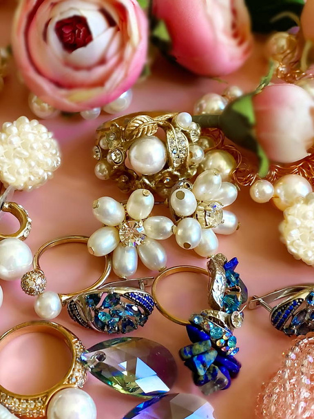 Šperky Zlatá modrá bílá perla kroužky náušnice křišťálový kámen s červenou a růžovou růží květinové šperky pozadí módní dámské doplňky  - Fotografie, Obrázek