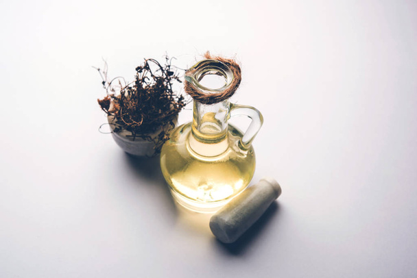 Aurvedic Maha Bhringraj або Mahabhringraj Волосяна олія з сухим листям і мінометом, селективний фокус - Фото, зображення