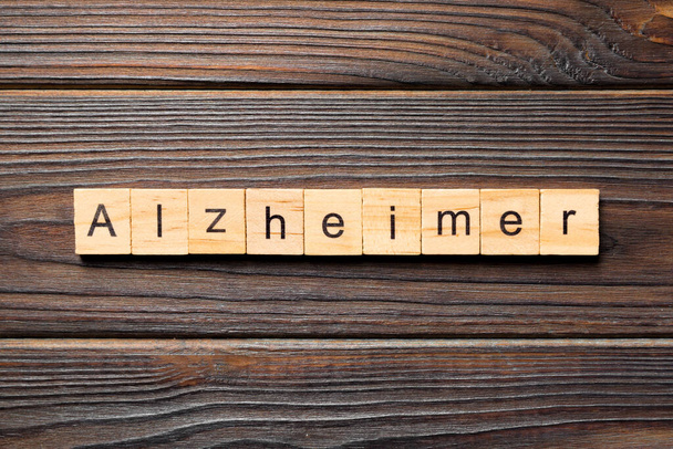 Слово Альцгеймера написано на деревянном блоке. Текст Альцгеймера на деревянном столе для Вашего дизайна, концепции
. - Фото, изображение