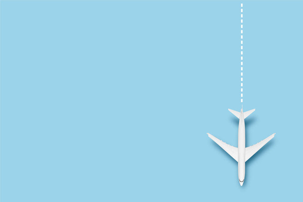 Vliegtuig en lijn die de route aangeven op een blauwe achtergrond. Concept reizen, vliegtickets, vlucht, route pallet. Een spandoek. Vlakke lay, bovenaanzicht. - Foto, afbeelding