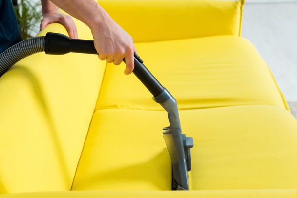 vista recortada de la limpieza en seco del sofá moderno con aspiradora
  - Foto, Imagen
