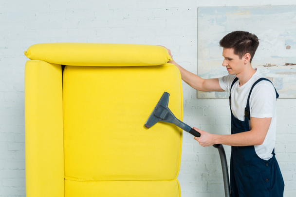 perfil de limpador na limpeza a seco uniforme sofá moderno com aspirador de pó
  - Foto, Imagem